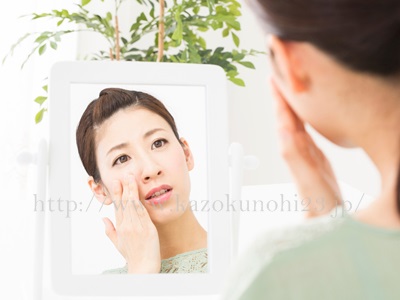 基礎化粧品のお試しセットを販売するサイトにて、シワ、たるみをスッキリ改善！年齢肌対策スキンケア方法とはの記事の紹介画像。30代女性が頬にてをあて鏡をのぞきこんでいます。