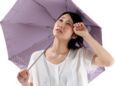 日焼け止めの効果を最大限にする！日焼け止めの正しい使い方とは？日傘をさして日焼け予防する女性。