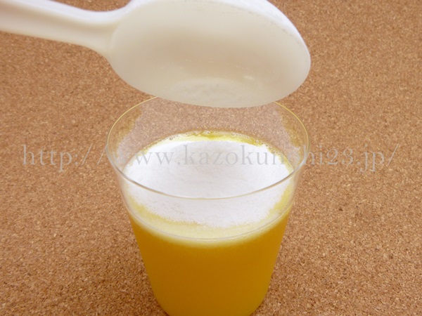 ニッピコラーゲンサプリメント100を5グラムオレンジジュースに投入して溶かそうとしているところ。