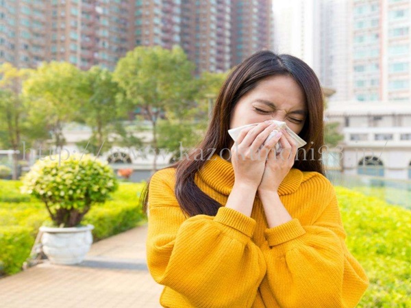 アレルギーの症状はさまざまですが、女性はくしゃみをしているところ。